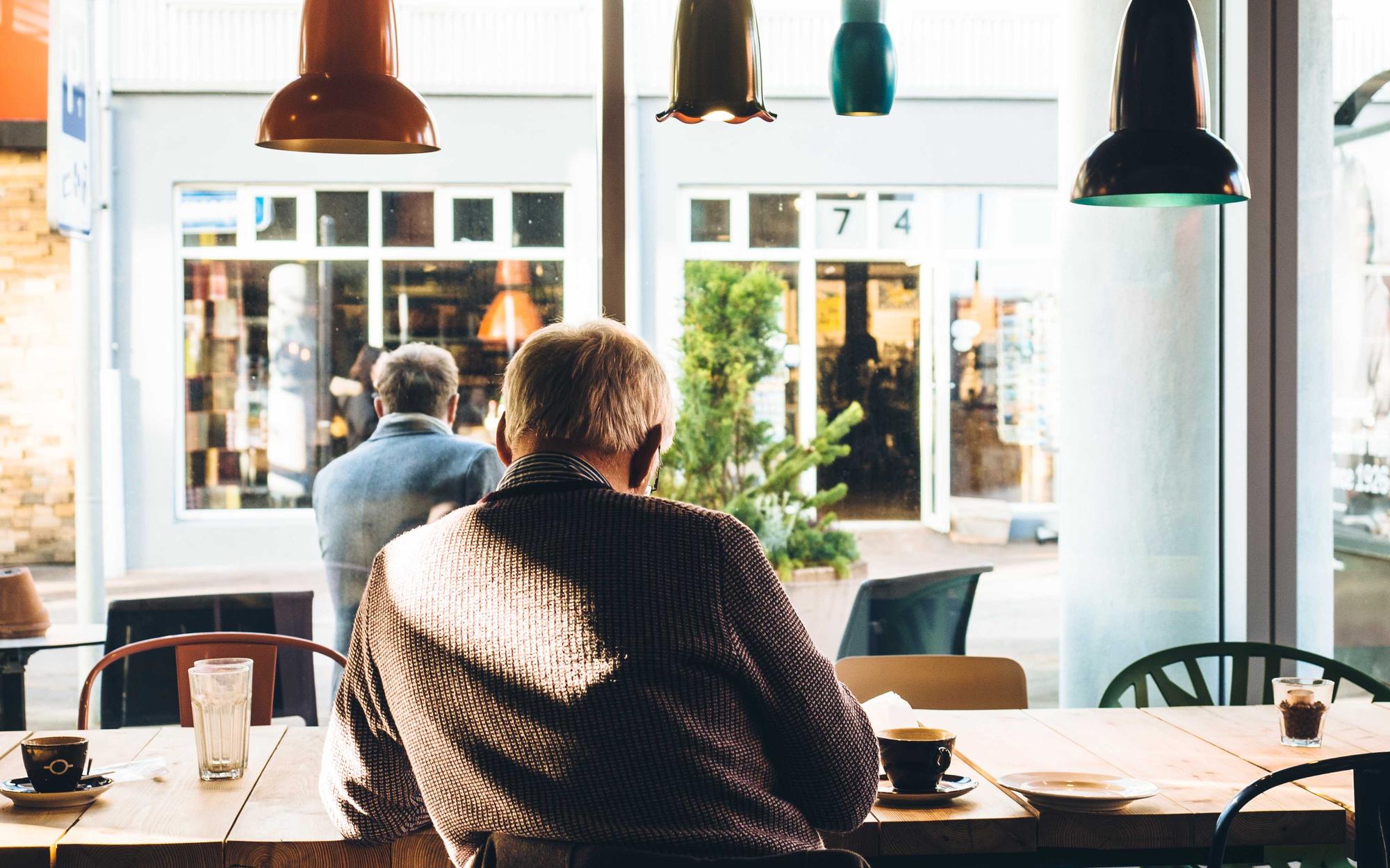 Colleagues talking at a table in a bright cafe