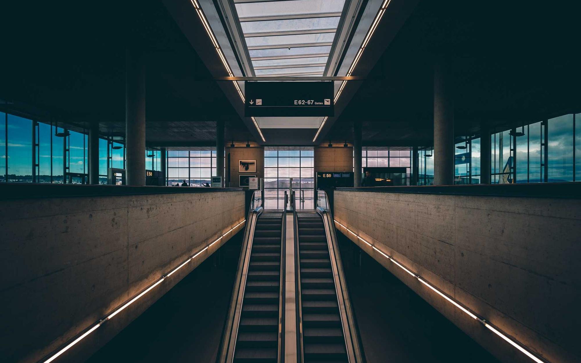 Symmetrical transit hall with escalators meeting at a central concourse